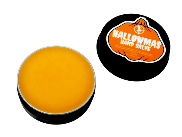 photo of hallowmas hand salve in black tin with pumpkin shaped label that reads hallowmas hand salve with ingredients listed and packaged in a black 2 oz tin