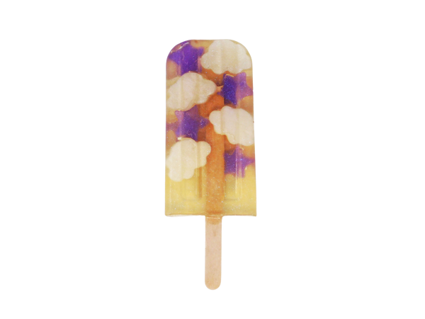 clear soap in the shape of a popsicle with purple stars, white clouds, and glitter