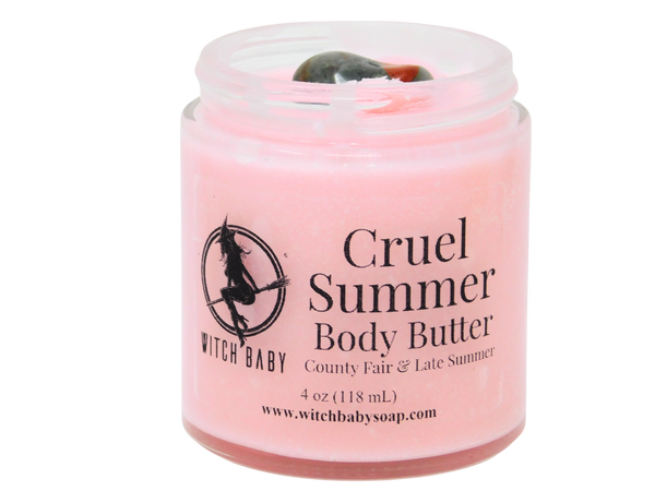 pink body butter in 4 oz glass jar with bloodstone on top and a clear label that reads: cruel summer body butter. county fair & late summer.