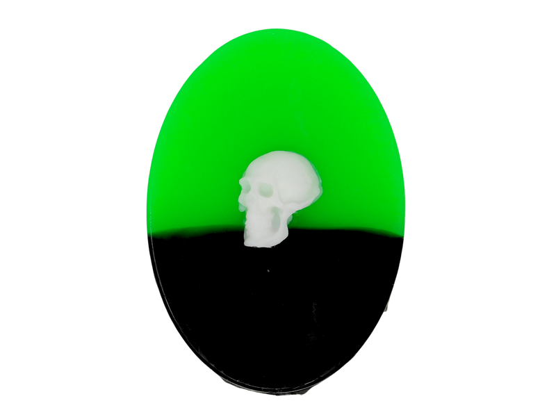 Half neon green half black oval soap with white skull embellishment on top