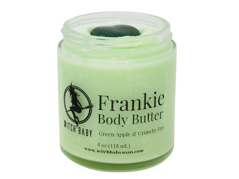 frankenstein green body butter in a 4 oz glass jar with green aventurine on top. Clear label reads: Frankie Body Butter. Green Apple & Crunchy Hay.