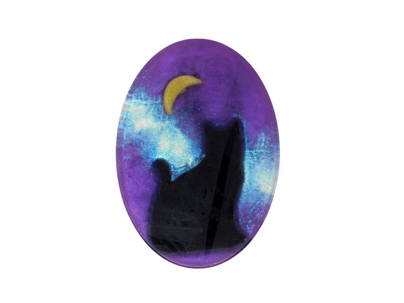 A purple oval shaped soap with a glitter galaxy background and a black cat sitting under a moon