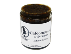 photo of cafeomancy body scrub pictured in 8 oz (236 mL) glass jar. Scrub is a dark brown with orange hues and a wet pumpkin puree texture speckled with sugar and coffee grinds. Label reads: Cafeomancy Body Scrub. Autumn Edition.