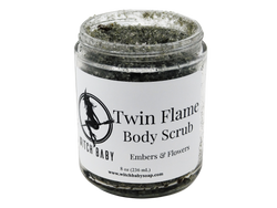 dark gray scharcoal scrub packaged in a 8 oz glass jar with a white label that reads: Twin Flame Body Scrub. Embers & Flowers.