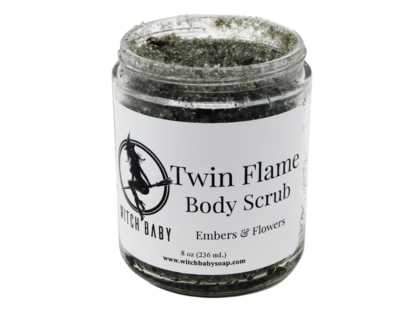 dark gray scharcoal scrub packaged in a 8 oz glass jar with a white label that reads: Twin Flame Body Scrub. Embers & Flowers.